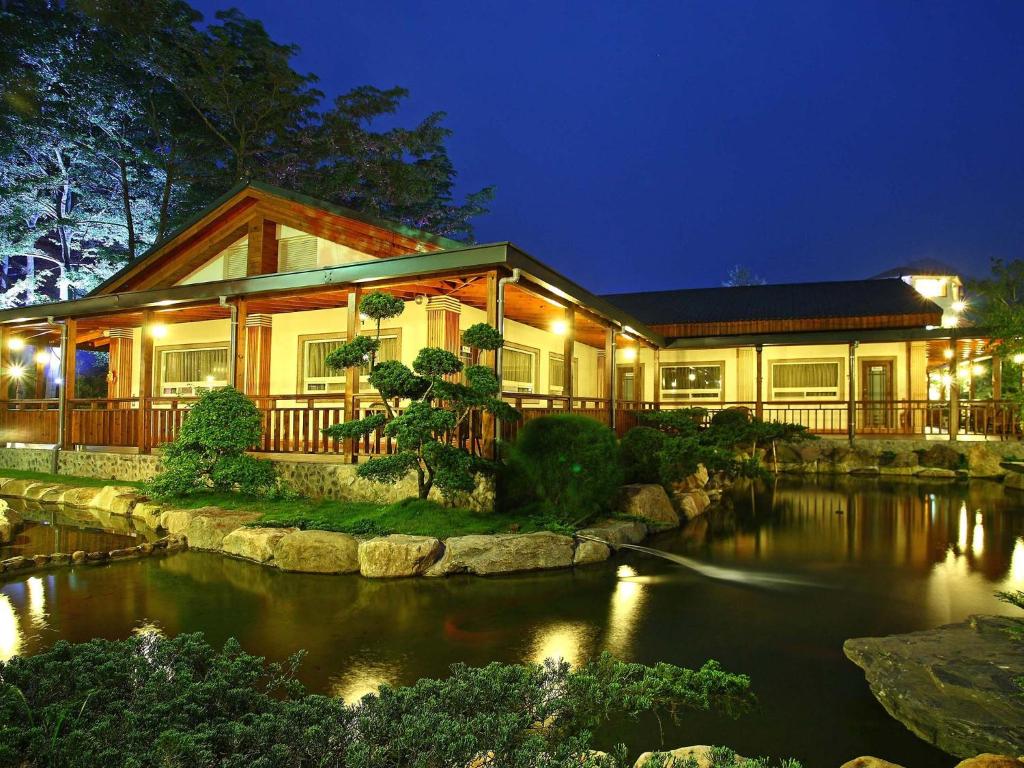 埔里鎮的住宿－綠莊飛閣渡假會館，前面有池塘的房子