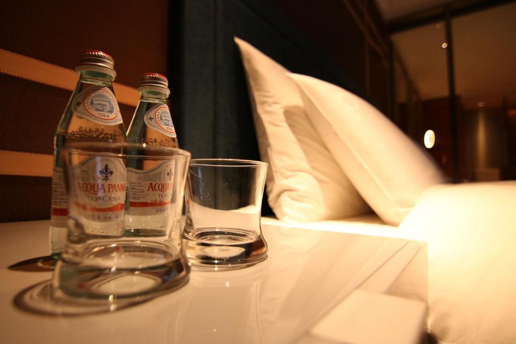 two bottles of beer and a glass on a table at H2O HOTEL in Kaohsiung