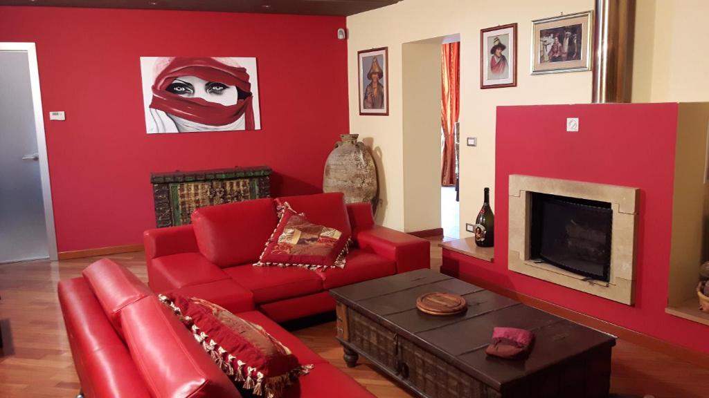 シラクーサにあるLucie Apartmentの赤いリビングルーム(赤いソファ、テレビ付)
