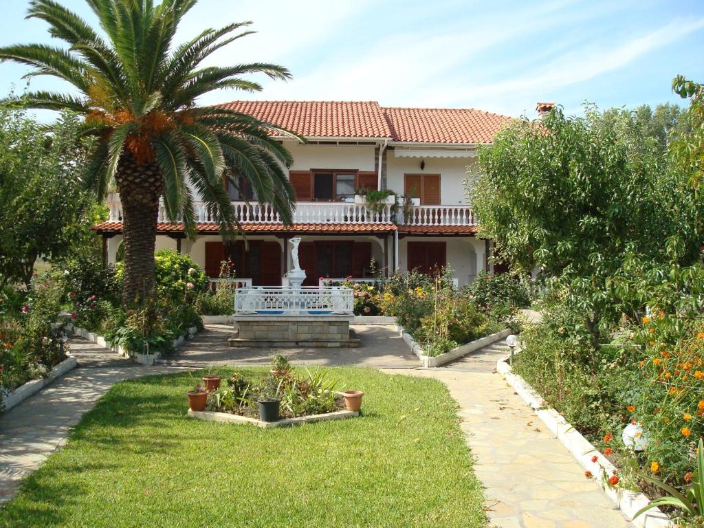 une maison avec un palmier et un jardin dans l'établissement Villa Tonia Apartments, à Sarti