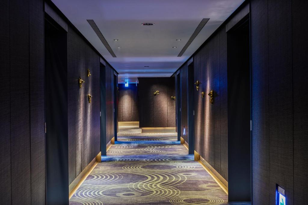 a corridor of a hotel with a carpeted hallway at H2O HOTEL in Kaohsiung