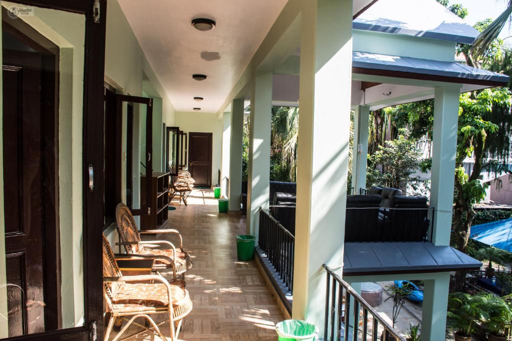 un portico di una casa con sedie e tavoli di Yeti Guest House a Pokhara