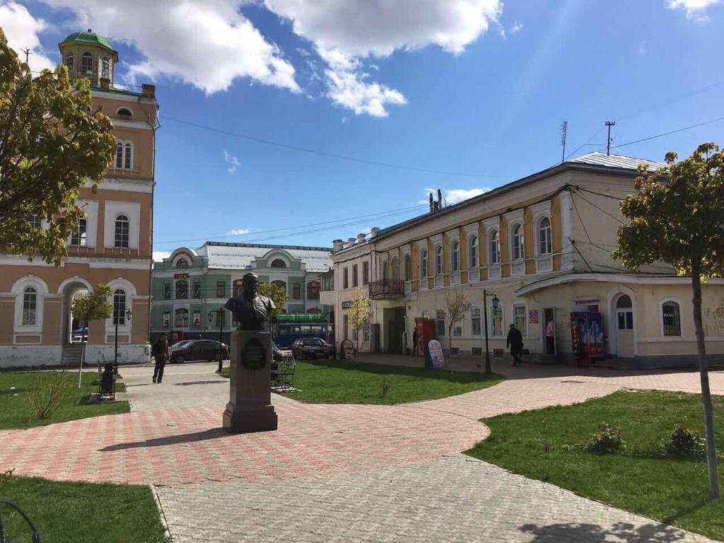 a statue in the middle of a town with a building at Apartment U bashni in Murom