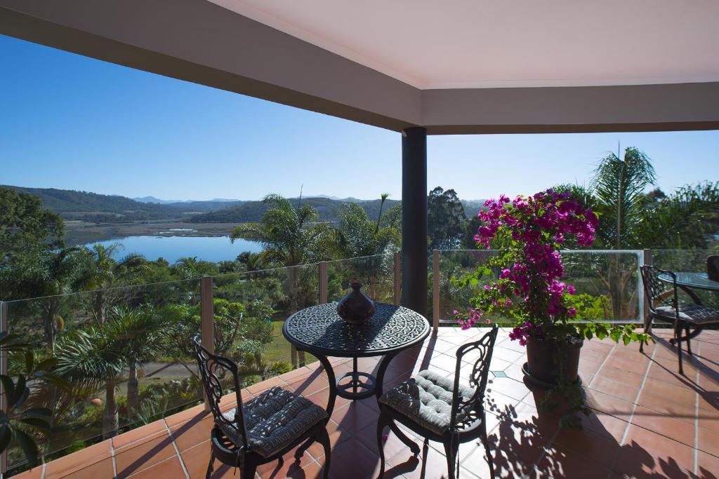 a balcony with a table and chairs and a view of a river at Lagoon View Villa in Knysna