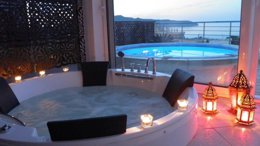 a jacuzzi tub on a balcony with a pool at Blue Villas in Agia Marina Nea Kydonias