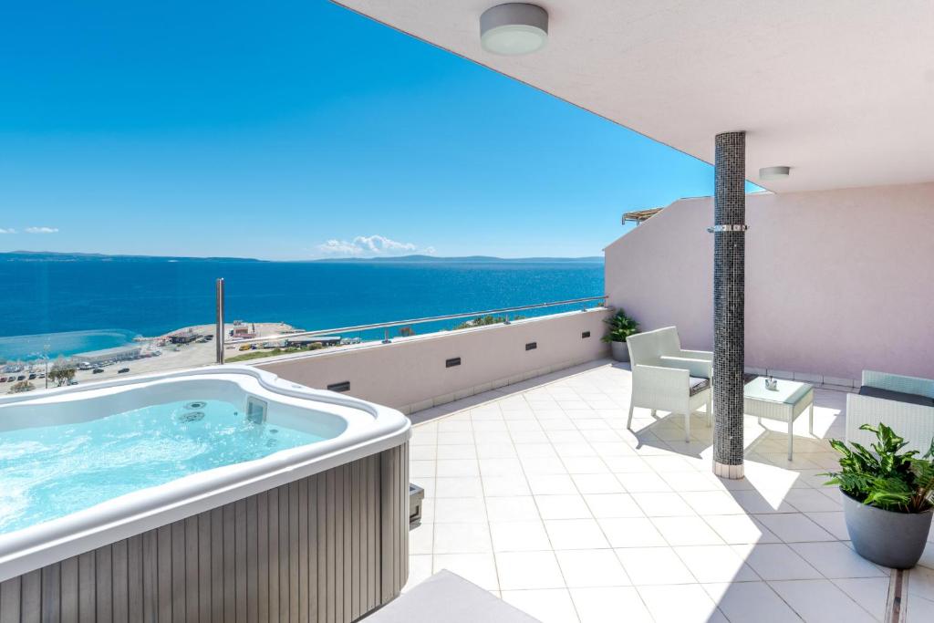 bañera de hidromasaje en el balcón con vistas al océano en Apartments Top View, en Split