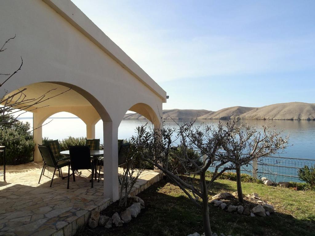 a pavilion with a table and chairs next to a lake at Vila Vinko in Miškovići