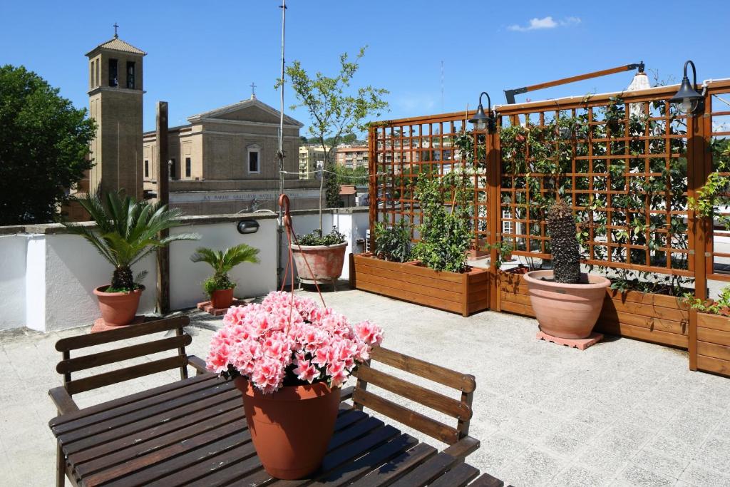 eine Terrasse mit zwei Bänken und Topfpflanzen in der Unterkunft Appartamento Delle Grazie in Rom