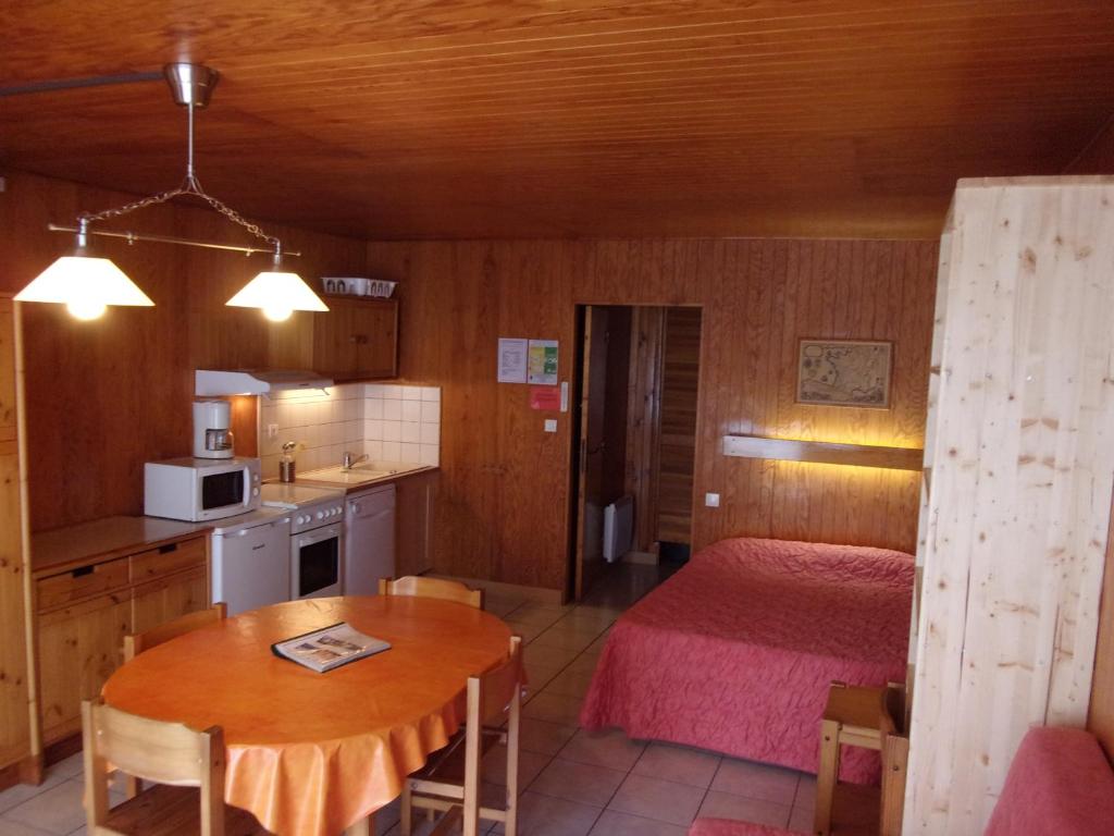 kuchnia oraz pokój z łóżkiem i stołem w obiekcie Le Champbourguet w mieście Super Besse