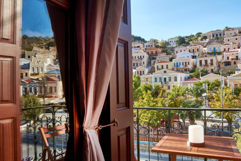 een kamer met een balkon met uitzicht op de stad bij Myrtia in Symi