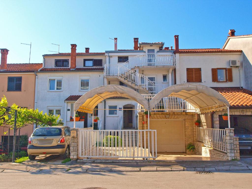 dom z bramą i samochodem zaparkowanym przed nią w obiekcie Apartments Tereza 1352 w Puli
