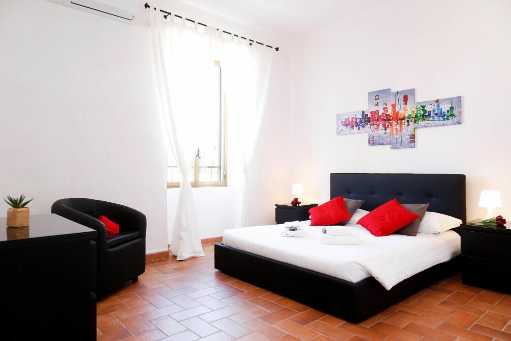ローマにあるRhome Away Trastevere - Saffiのベッドルーム1室(赤い枕と椅子付きのベッド1台付)