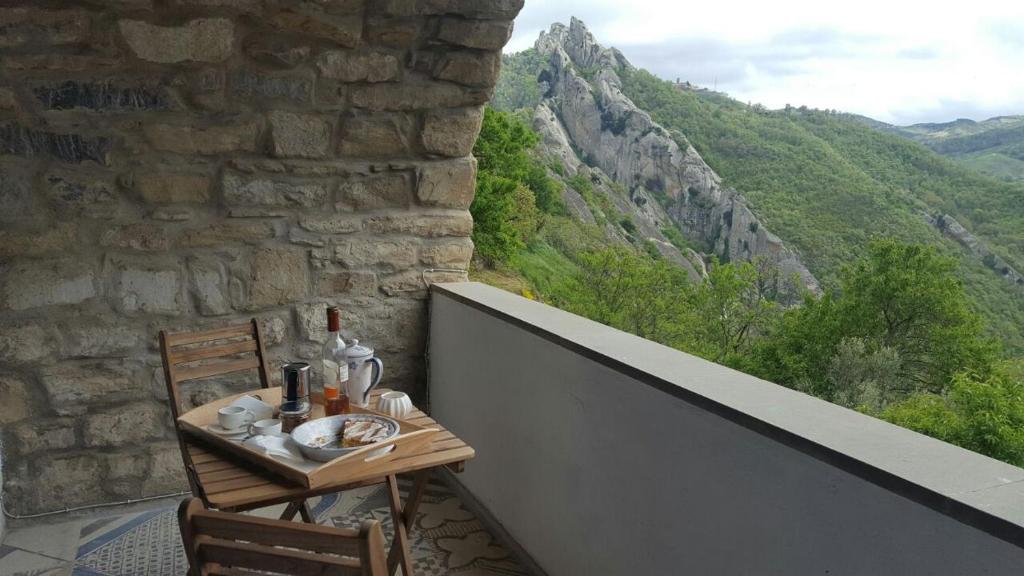 a table and chairs on a balcony with a view at Casa dell'Avventura in Castelmezzano