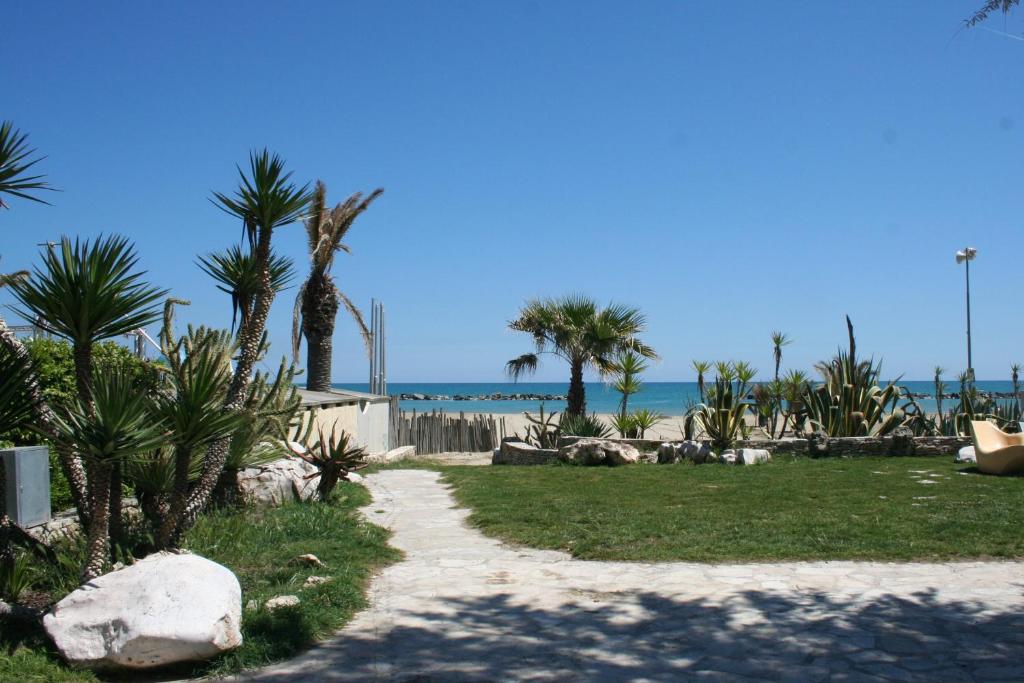 サン・ベネデット・デル・トロントにあるAppartamenti Vacanza Mareの椰子の木と海に続く遊歩道