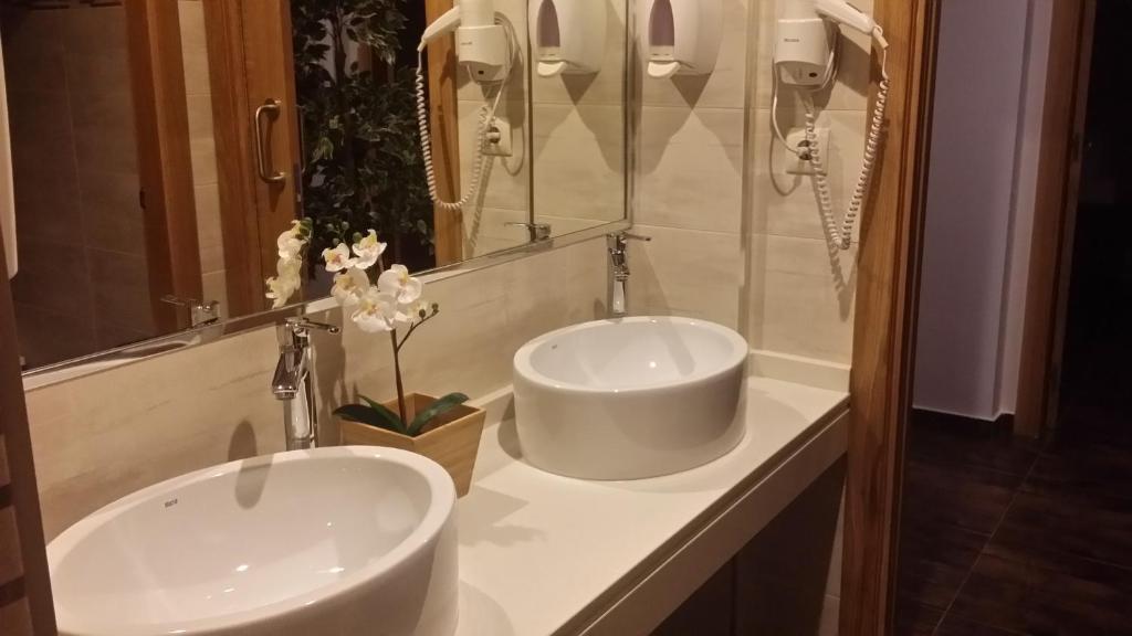 Baño con 2 lavabos y espejo en Albergue Ultreia en Arzúa
