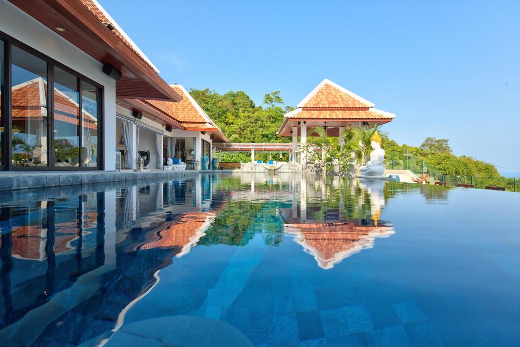 a swimming pool in front of a house with a building at Nirvana Villa & Boutique Hôtel in Taling Ngam Beach