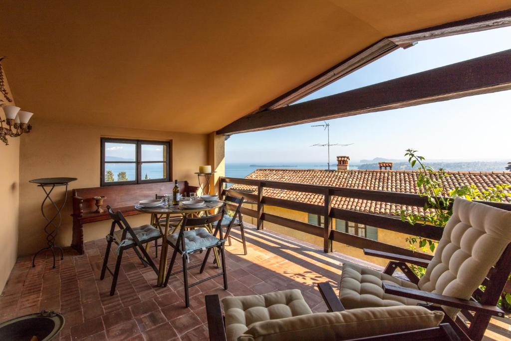 a room with a balcony with a table and chairs at La Baita in Gardone Riviera