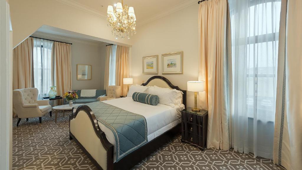 a bedroom with a bed and a table and a chair at Sydney Boutique Inn & Suites in Charlottetown