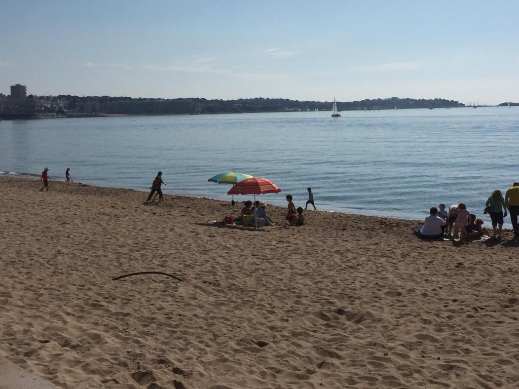 um grupo de pessoas sentadas numa praia com guarda-sóis em Fréjus Studio em Fréjus