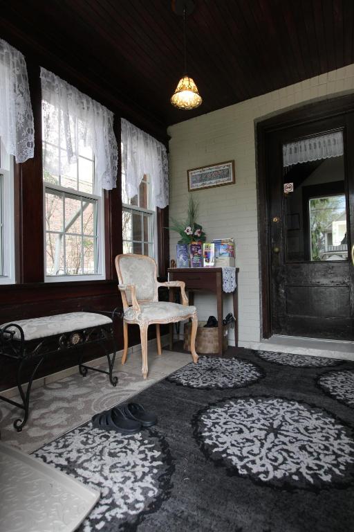 a living room with a chair and a bench and a table at Ambiance By The Falls B&B in Niagara Falls