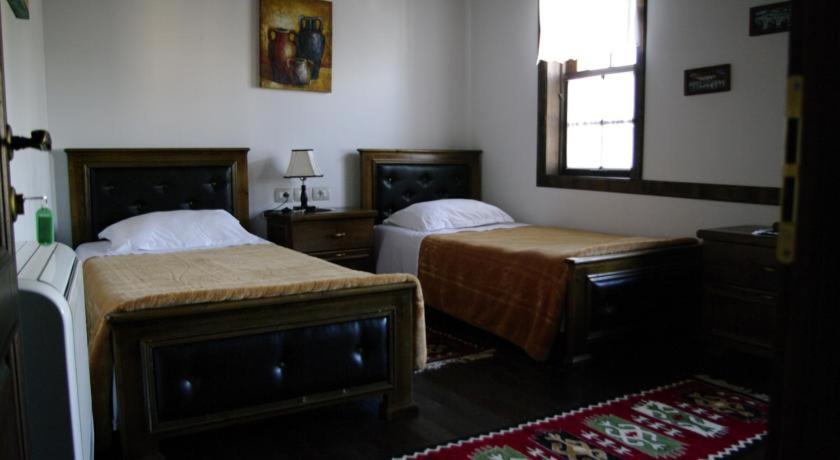 a bedroom with two beds and a window at Hotel Klea in Berat