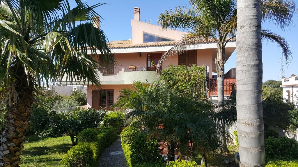 un edificio con palmeras delante en Villa Ottavia, en Noto