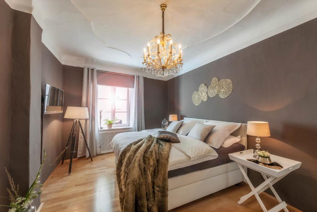 a bedroom with a bed and a chandelier at PASSAU mittendrin in Passau