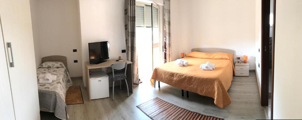 a bedroom with a bed and a desk and a television at Raxul Room in Sestu