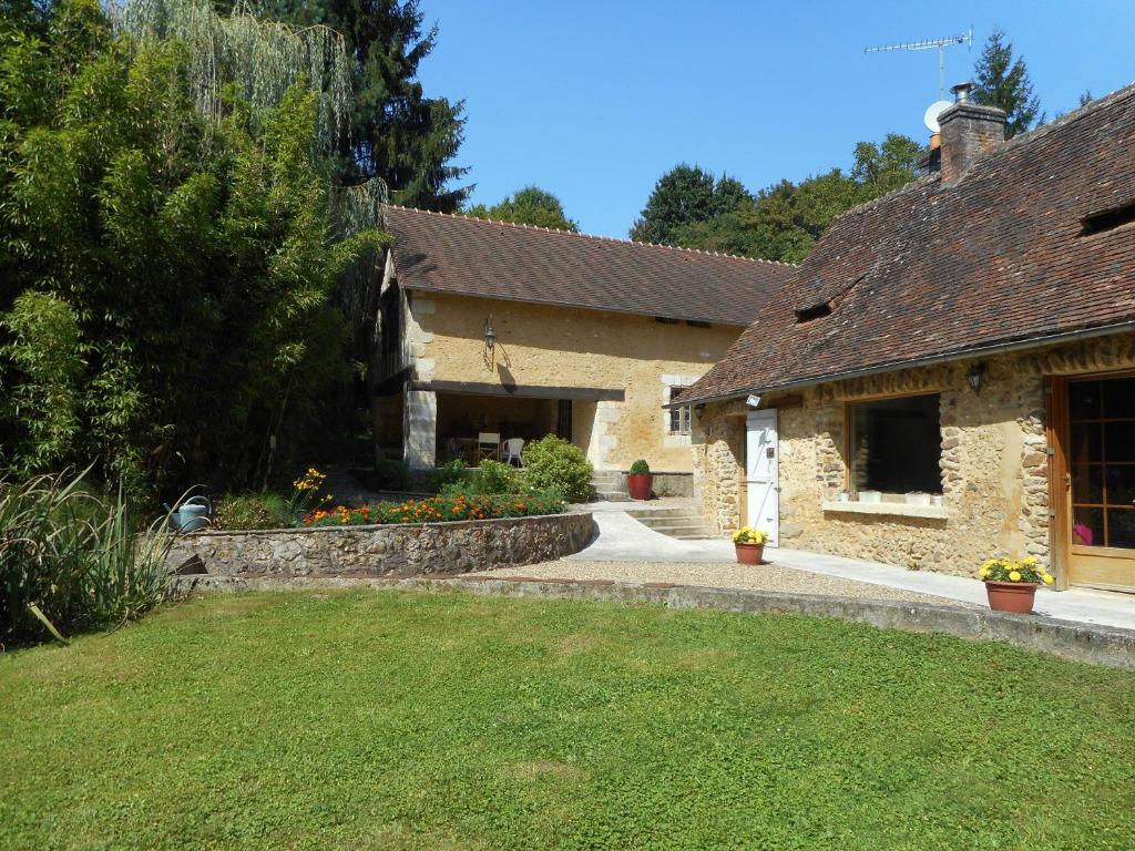 a stone house with a garden and a yard at Le Moulin de Monternault in Montreuil-le-Henri