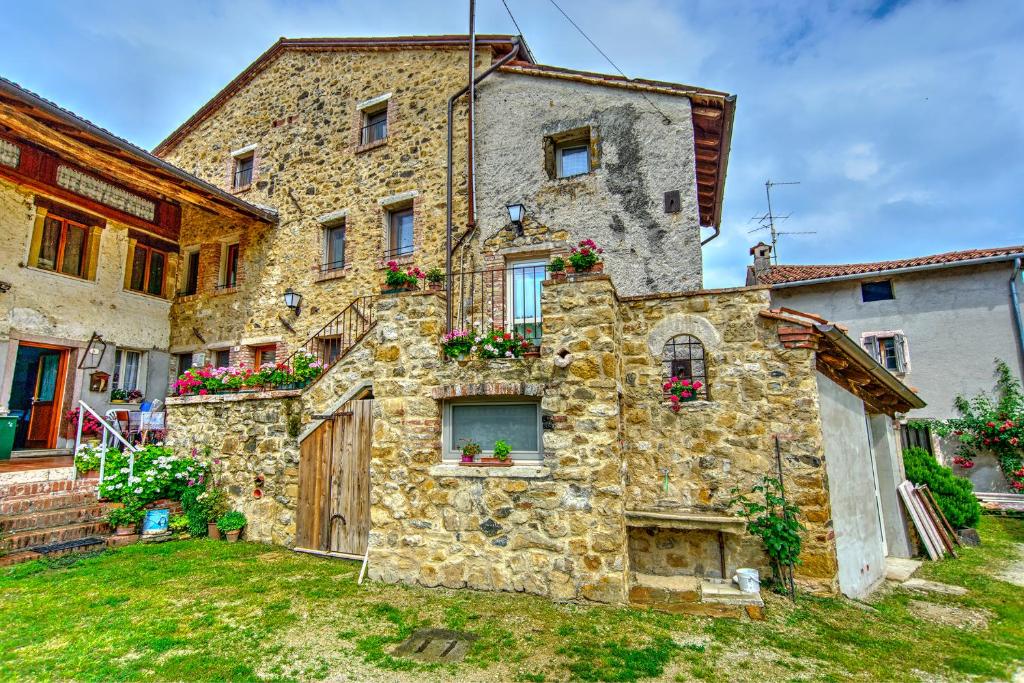 een oud stenen huis met bloembakken erop bij Agriturismo "Antico Borgo" in Marostica