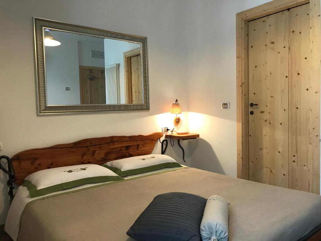 a bedroom with a bed with a large mirror at Giardino alla Torre Bed&Breakfast in Dro