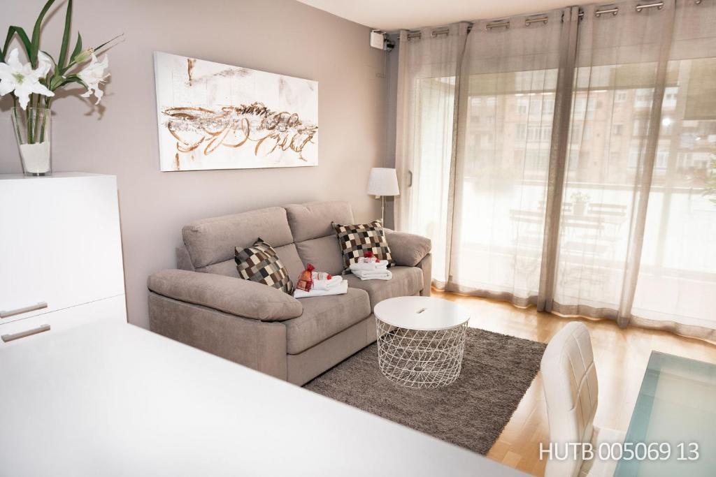uma sala de estar com um sofá e uma cadeira em Alcam Aribau em Barcelona