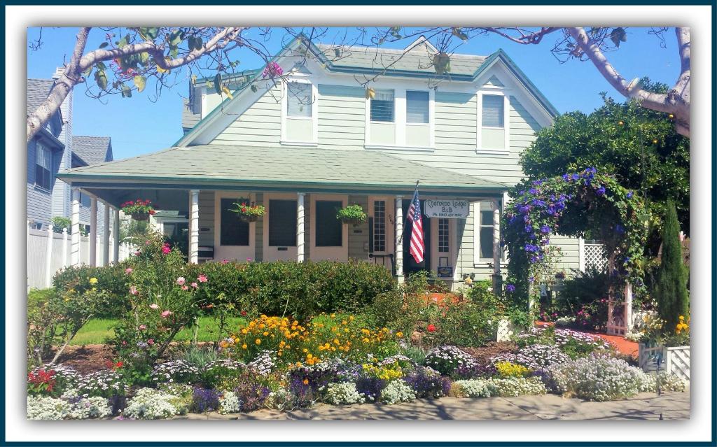 a house with a flower garden in front of it at Cherokee Lodge in San Diego
