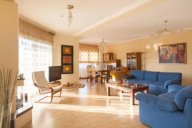 a living room with a blue couch and a table at House,1000m from the beach in Lagonissi