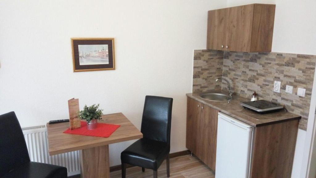 una pequeña cocina con mesa y fregadero en Apartments Victoria 022, en Vrdnik