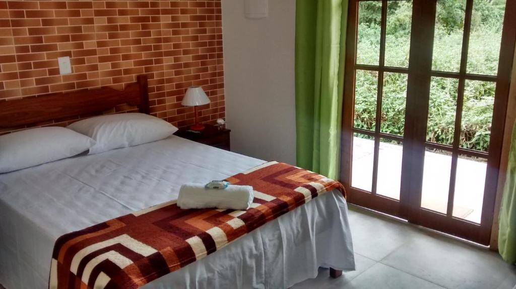 ein Schlafzimmer mit einem Bett und einer Handtasche darauf in der Unterkunft Repouso Clave de Sol in Paraty