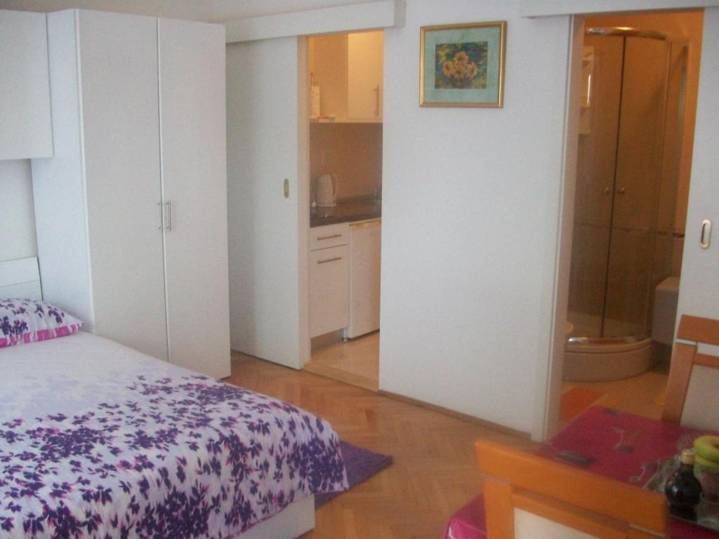 ein kleines Schlafzimmer mit einem Bett und einem Badezimmer in der Unterkunft Studio Dominik in Makarska