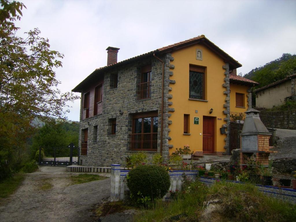 an old stone house with a driveway in front of it at El Mirador de Valdedios " Casa Friera" in Puelles
