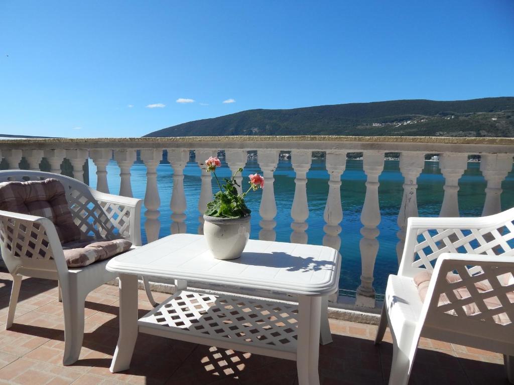 einen Tisch mit Topfpflanze auf dem Balkon in der Unterkunft Apartments Sun House in Herceg-Novi