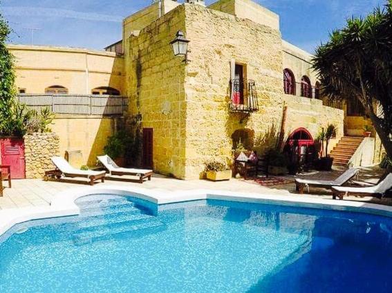a large swimming pool in front of a building at Shanti Ghar Gozo in San Lawrenz