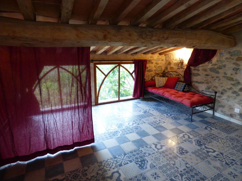 a living room with a red couch and a window at Mas de la Fariole in Caixas