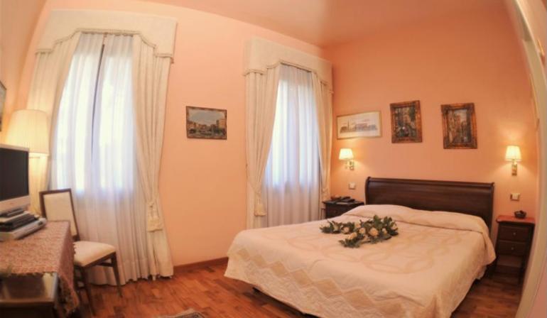a bedroom with a bed with a flower arrangement on it at Villa Crispi in Mestre