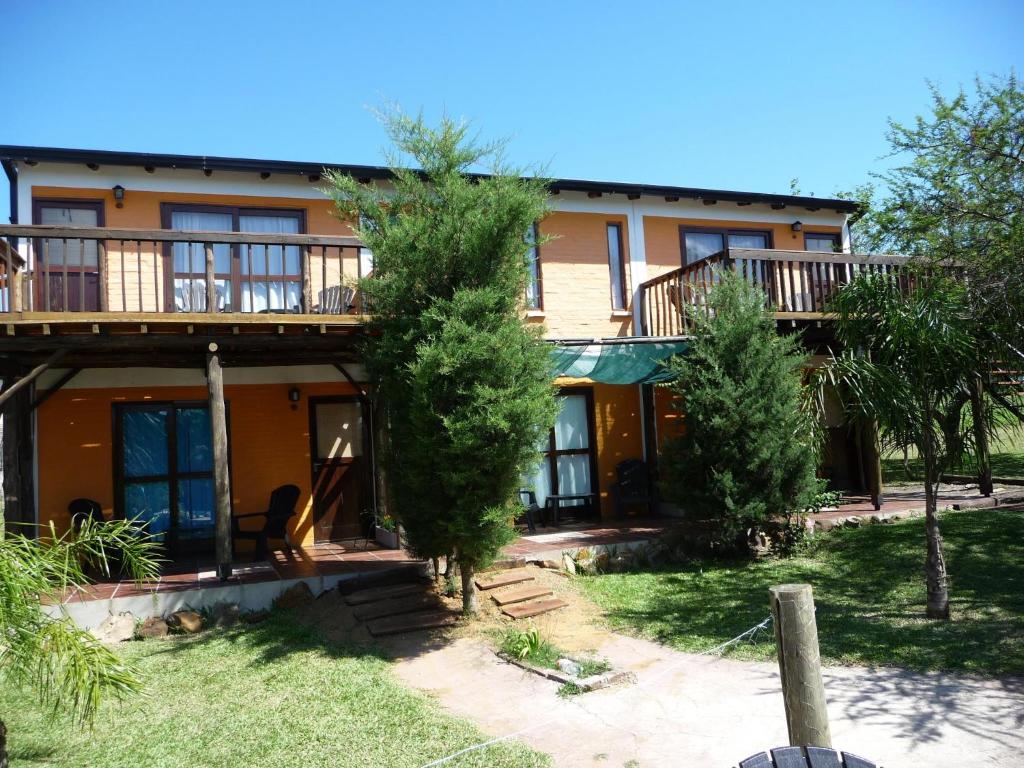 a house with a balcony and trees in front of it at Cabanas El Paramo in Colón