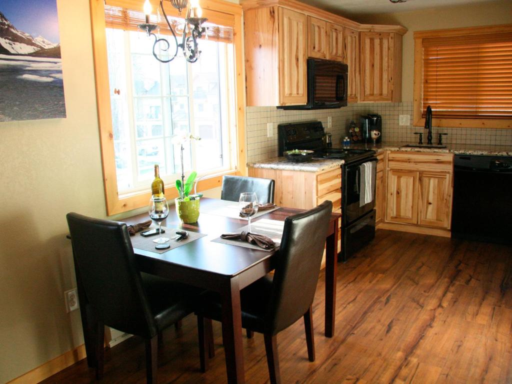 a kitchen with a wooden table with chairs and a dining room at Montana Style Downtown Condo in Whitefish