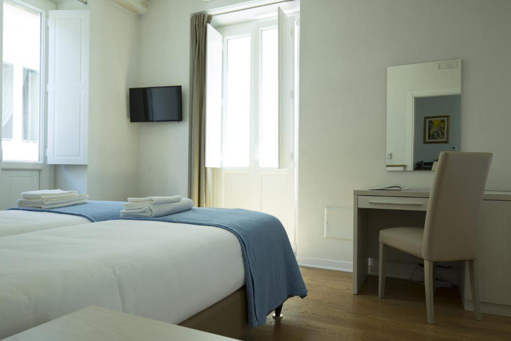 a bedroom with a bed and a desk and a chair at B&B Cerasarella in Vibo Valentia