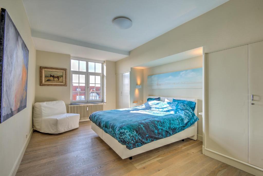 a bedroom with a bed and a chair in it at Res. Golf Zoute in Knokke-Heist