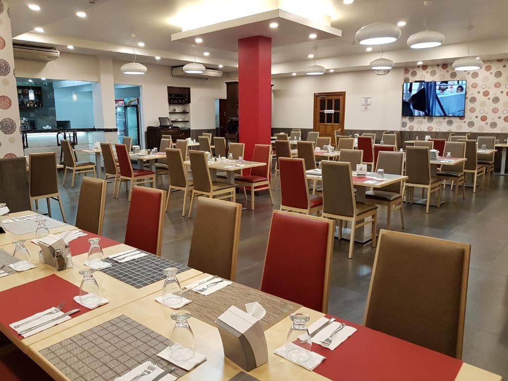 a conference room with tables and chairs and a screen at Hotel Alcala in David