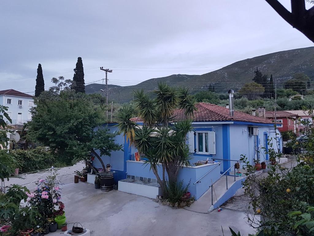 een blauw huis met een palmboom ervoor bij Kallithea Holiday Homes in Kallithea