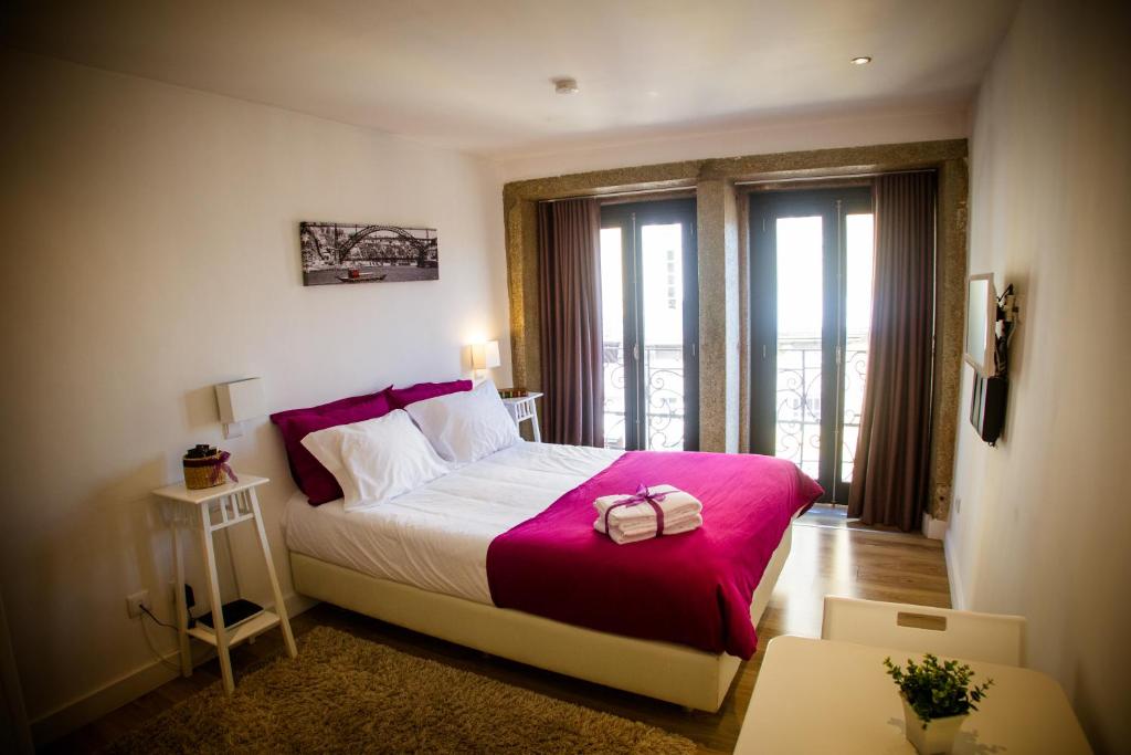 una camera da letto con un grande letto con una coperta rosa di Historical Porto Studios a Porto