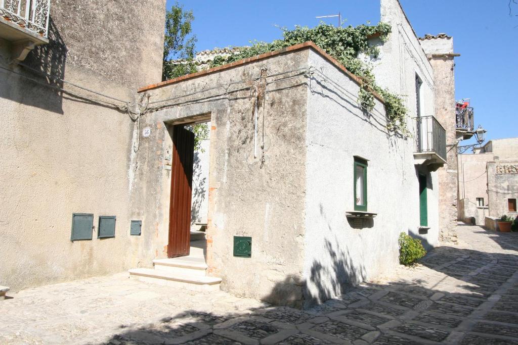 um edifício antigo com uma porta aberta numa rua em Case Bruno Residenze Tipiche em Erice